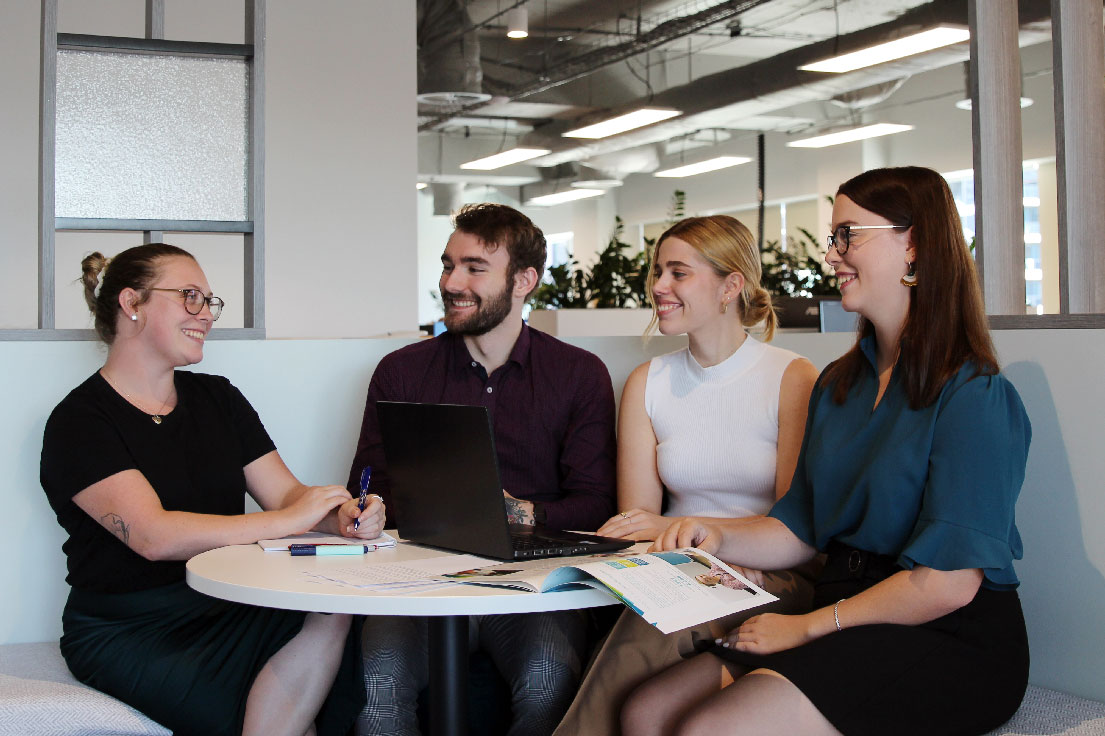Staff sitting at office table discussing projects